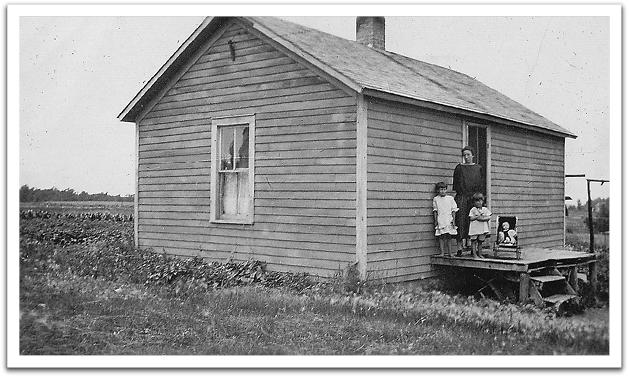 Maggie Reitter with Leona, Helen, and a doll on the front porch of the Reitter house, about 1924.