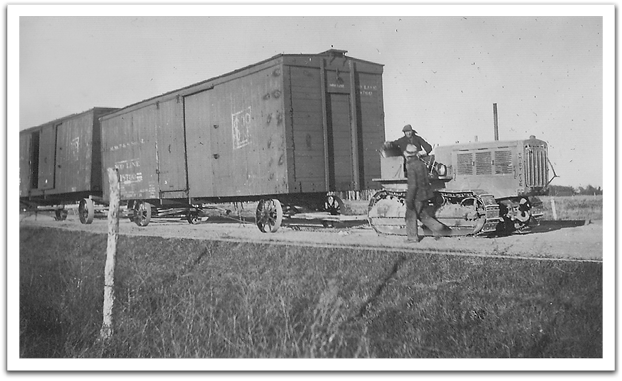 Towing old railroad cars. George Reitter on the tractor and probably Ray Wichterman walking, year unknown.