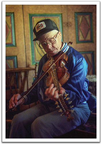 Oscar Flateland playing a "hardanger violin" in the Valle area, 1990. It has eight strings, four of which are sympathetic, giving it a unique and, to the uninitiated ear, a somewhat harsh sound. Photo by Byron Flateland.