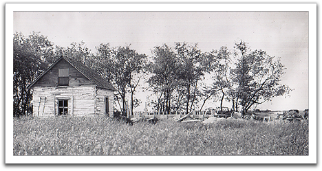 The old log house built by Svein Flateland in the foreground, with concrete mixer and forms for Oscar and Helen's new house in the background, summer, 1947.