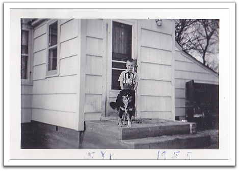Byron and Laddie in front of new entry room to the house with new shake-shingle style siding, November, 1955.