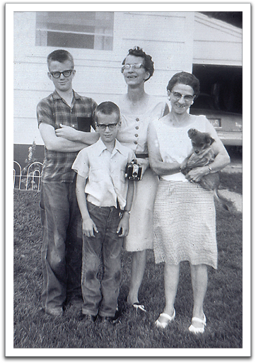 Byron, Myles, Helen, and Ida Flateland,  holding new puppy Spanky. By this time, Myles, too, had begun experiencing myopia inherited from Helen and had gotten glasses.